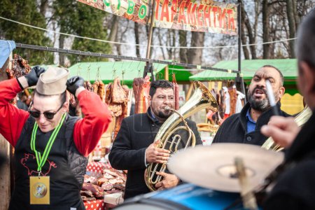 Téléchargez les photos : KACAREVO, SERBIE - 14 FÉVRIER 2024 : trubaci, groupe de musique roma, traditionnel de la serbie, jouer de la trompette, du tuba et des instruments traditionnels en slaninijada, marché serbe dédié à la saucisse. - en image libre de droit