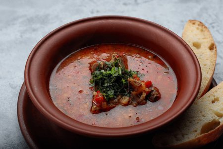 Photo for Georgian soup Kharcho with meat in a clay pot with bread - Royalty Free Image
