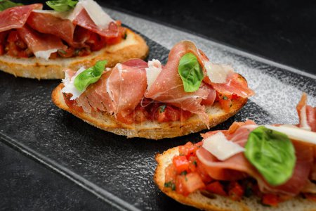 Photo for Mouthwatering Bruschetta Topped with Smoked Salmon, Ham and Parmesan Cheese - Royalty Free Image