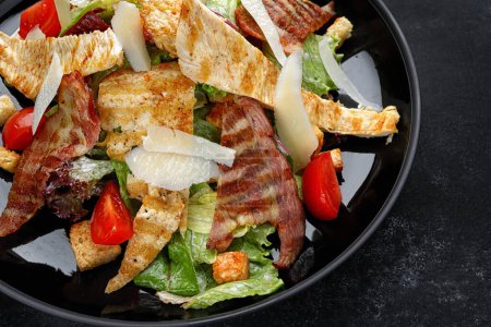 Photo for Delicious Caesar salad topped with crispy bacon, grilled chicken, and Parmesan cheese - Royalty Free Image