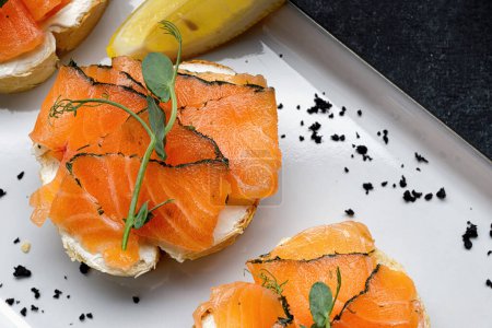 Téléchargez les photos : Bruschetta with salmon and butter, on dark background. Banner - en image libre de droit