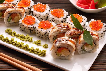 Photo for Exquisite sushi rolls with traditional accompaniments, with wasabi and ginger - Royalty Free Image