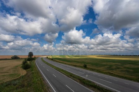 Highway, fields. beautiful sky with white clouds
