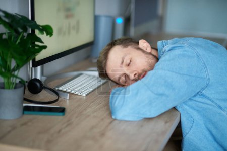 Photo for Software developer of web designer: caucasian bearded tired IT guy sleeping and awaking at working place in office. Man sleeping at desk, tired of stressful job burnout at work, lack energy - Royalty Free Image