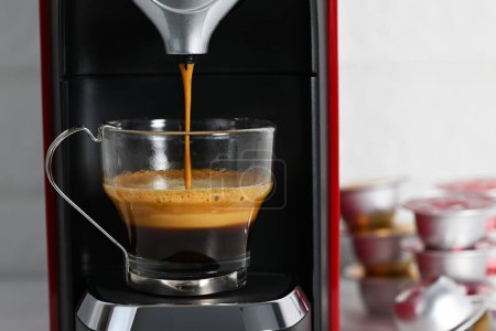 Téléchargez les photos : Machine expresso faisant du café dans une tasse en verre - en image libre de droit