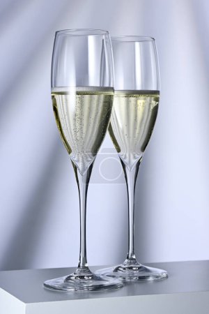Téléchargez les photos : Deux verres avec champagne sur fond éclairé - en image libre de droit