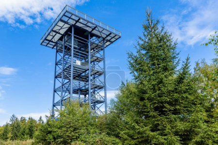 Foto de Lesna - Stara Knizeci Hut, República Checa - 17 de septiembre de 2023: Vista de la torre de vigía de acero llamada Havran de pie en el bosque rodeado de árboles verdes. Día soleado de otoño con cielo azul. - Imagen libre de derechos