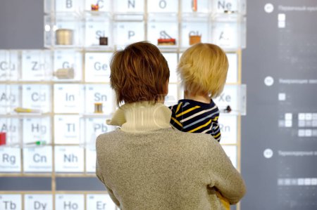Little boy and woman looking an exposition in a scientific museum. Child is interested in chemistry. Education and entertainment for children. Activities for family with preschooler kids.