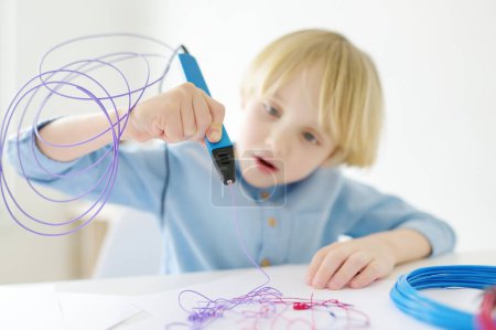 Téléchargez les photos : Petit garçon apprenant à faire le modèle avec stylo d'impression 3D. Enfant jouant avec un nouveau jouet moderne pour la créativité. Du bricolage. Enseignement des STIM et des STEAM. - en image libre de droit