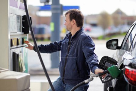 Retrato del hombre de mediana edad llenando combustible de gasolina en el coche
