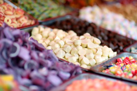 Muchos colores gomosos, gelatina, caramelo, caramelo y caramelos de chocolate se venden en la tienda. Surtido de dulces multicolores como fondo alimentario. Textura colorida. Primer plano.