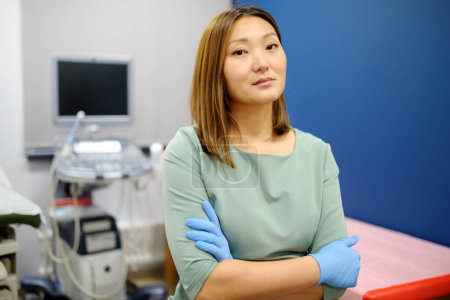 Téléchargez les photos : Portrait de gynécologue obstétricienne asiatique au bureau pendant le travail. Médecin professionnel et responsable travaillant dans une clinique de pointe de la ville. - en image libre de droit