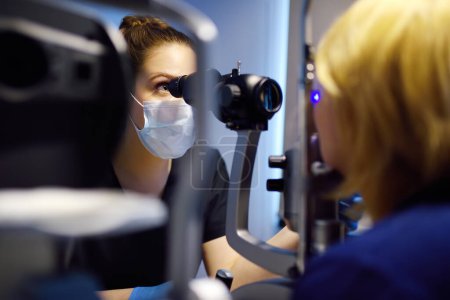 Lampe à fente examen oculaire avec ophtalmologiste. Patient lors de la visite par oculiste pour l'examen de l'analyse biomicroscopique des paupières, sclérose, conjonctive, iris, lentille, cornée. Contrôle de la rétine et du fond d'oeil.