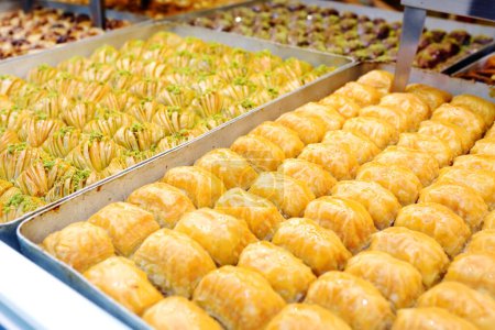 Assortment of traditional turkish dessert baklava on a showcase of shop. Sweets as a food background. Texture. Close-up
