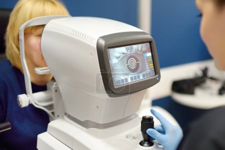 Patient lors de la visite à l'optométriste pour l'analyse microscopique des paupières, sclérose, conjonctive, iris, lentille, cornée. Examen du fond d'oeil de la femme mature par un ophtalmologiste à l'aide d'un scanner rétinien