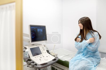 Una mujer joven en una cita con un mamólogo para examinar las glándulas mamarias y los ganglios linfáticos. Paciente esperando examen de ultrasonido ginecológico. Concientización sobre el cáncer de mama