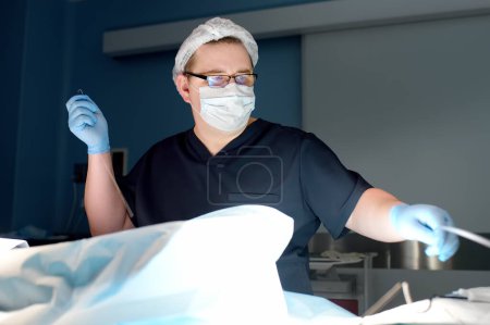 Der professionelle Gefäßchirurg befindet sich während der Venenoperation im Operationssaal der Klinik. Phlebectomie. Es gibt eine endovaskuläre Venenoperation.