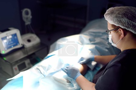 Der professionelle Gefäßchirurg befindet sich während der Venenoperation im Operationssaal der Klinik. Phlebectomie. Moderne Technologie zur Behandlung von tiefen Venenthrombosen. DVT