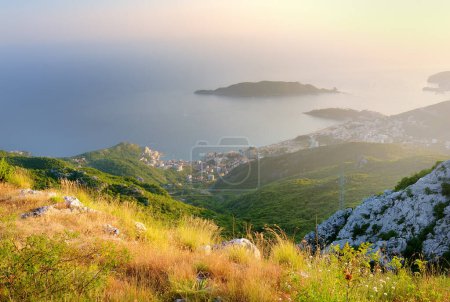 Luftaufnahme der Budva Riviera vom Fort Kosmach bei Sonnenuntergang. Alte Festungsruinen liegen in den Bergen in der Nähe von Budva in Montenegro. Wunderschöne panoramische Landschaft der Adriaküste mit der Insel Sankt Nikolai.