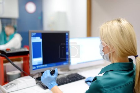 Radiologiste femelle va prendre rayons X du patient dans la salle de rayons X de la clinique moderne. Photo rapprochée du médecin main appuie sur le bouton pour l'exécution de l'examen médical.