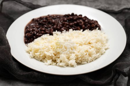 Photo for Black beans and boiled rice on white big dish. - Royalty Free Image
