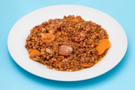 Photo for Lentils with chorizo and carrot on white dish. Typical Spanish recipe. - Royalty Free Image