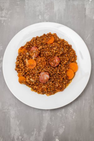 Photo for Lentils with chorizo and carrot on white dish. Typical Spanish recipe. - Royalty Free Image