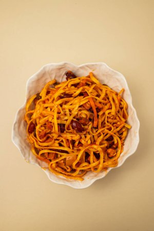 Nudeln Tai-Stil gemischt mit würzigen Tomaten und Fleisch in weißer Schüssel