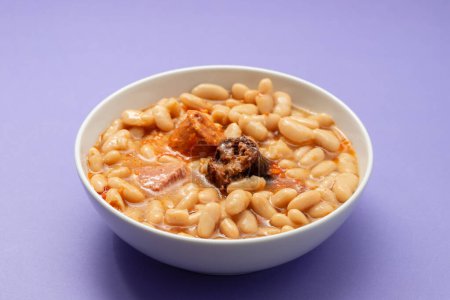 fabada asturiana, a typical spanish bean stew in white big bowl