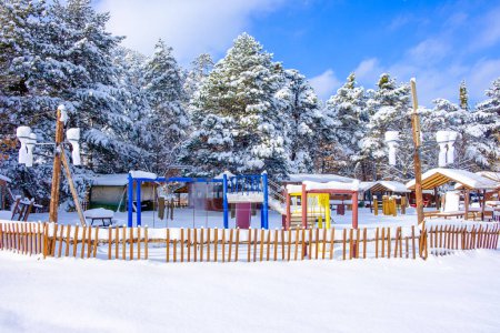 Téléchargez les photos : Cabanes couvertes de neige et parc - en image libre de droit