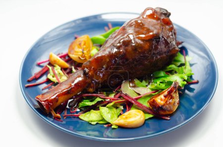 Photo for Delicious Lamb shank with red wine and rosemary gravy served on the mixed leaf salad, on the blue plate, an exclusive dish - Royalty Free Image