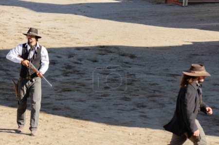 Foto de ALMERIA, ESPAÑA - 17 DE DICIEMBRE DE 2022 Vestidos con trajes distintivos del Salvaje Oeste, los actores de una ciudad occidental montan un espectáculo de robo a un banco - Imagen libre de derechos