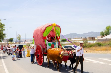 Photo for NERJA, SPAIN - 15 MAY 2022 City residents, carriages, carts, horses, oxen and tractors, as well as local farmers coming from neighbouring villages all dressed in the best and most beautiful traditional folk costumes - Royalty Free Image