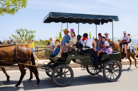 Photo for NERJA, SPAIN - 15 MAY 2022 City residents, carriages, carts, horses, oxen and tractors, as well as local farmers coming from neighbouring villages all dressed in the best and most beautiful traditional folk costumes - Royalty Free Image