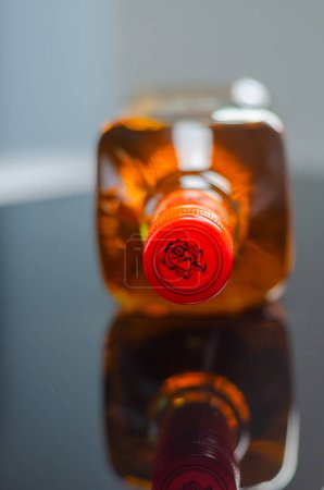Foto de LONDRES, Reino Unido - 08 MARZO 2024 Una botella de tequila tradicional reposado diseñada por el artista mexicano Pogo con un clásico motivo craneal realzado con flores de caléndula naranja que crecen de la planta de agave - Imagen libre de derechos