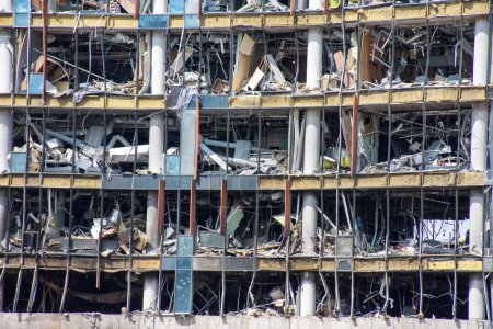 Zerstörtes Einkaufszentrum durch Raketenbeschuss mit zerbrochenen Scheiben, zerstörte Betonkonstruktion. Das Foto kann für Werbung, Präsentationen verwendet werden.
