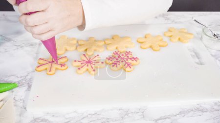 Téléchargez les photos : Pas à pas. Biscuits au sucre en forme de flocon de neige glacé avec glaçage royal rose. - en image libre de droit