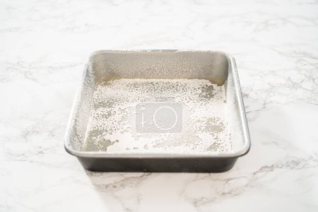 Téléchargez les photos : Graissage plaque de cuisson carrée en métal pour cuire des bonbons. - en image libre de droit