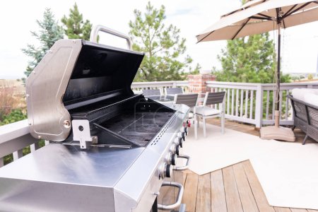 Outdoor six-burner gas grill on the back patio of a luxury single-family home.