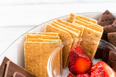 Photo for Arranging fruit s'mores charcuterie board on a white tray. - Royalty Free Image
