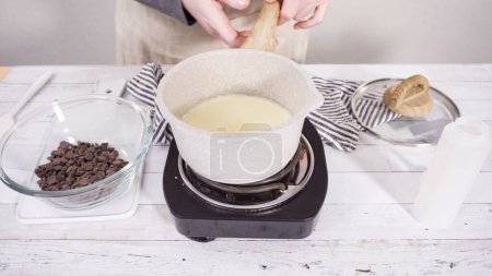 Téléchargez les photos : Préparation de ganache au chocolat maison pour cupcakes aux framboises au chocolat. - en image libre de droit