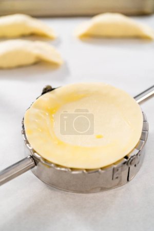 Téléchargez les photos : Remplir la pâte empanada avec du remplissage d'œufs pour faire des empanadas petit déjeuner avec des œufs et des patates douces. - en image libre de droit