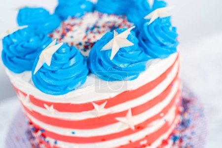 Photo for Decorating chocolate cake with white, red, and blue buttercream frosting for July 4th celebration. - Royalty Free Image