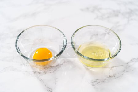 Photo for Separating egg whites and egg yolks into small bowls. - Royalty Free Image