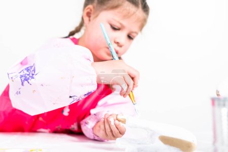 Téléchargez les photos : Petite fille travaillant sur son projet d'art pour l'enseignement à distance à la maison pendant la COVID-19 pendémique. - en image libre de droit