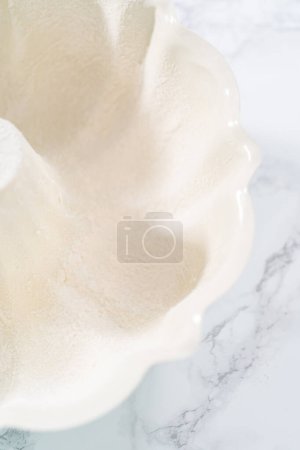 Téléchargez les photos : Graissage du moule à gâteaux pour cuire le gâteau aux gâteaux à la citrouille. - en image libre de droit