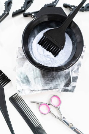 Haarfärbepulver in einer schwarzen Kunststoff-Mischschüssel auf weißem Hintergrund.