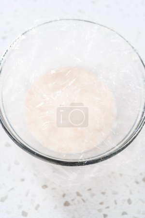 Photo for Activating dry yeast in a glass mixing bowl to bake naan dippers. - Royalty Free Image