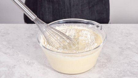 Schritt für Schritt. Zutaten in einer Glasschüssel mischen, um Kokosbananen-Pfannkuchen zuzubereiten.