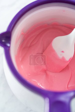 Photo for Melting pink chocolate melts to make mini pink chocolates. - Royalty Free Image